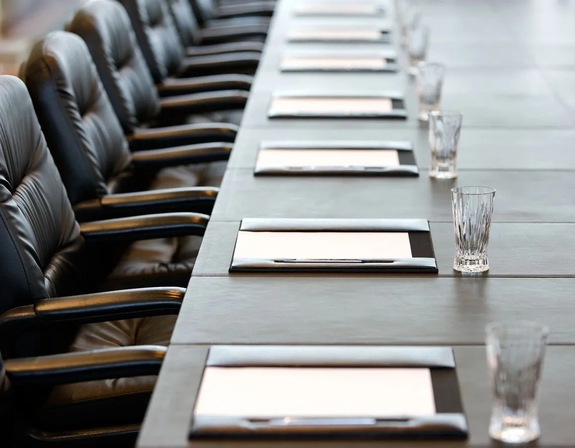 A long table with many empty chairs on it